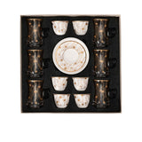 CASA BLU 18-piece luxury tea and coffee set in a black foam-lined gift box, featuring 6 smoked glass tea cups with handles, 6 white porcelain Gawa cups, and matching gold-patterned saucers.