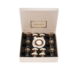 CASA BLU 18-piece luxury beverage set in a black display box, featuring six clear tea glasses with gold rims, six white and gold Arabic coffee cups, and stacked gold-patterned saucers.