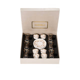 CASA BLU 18-piece luxury tea and coffee set in a black foam-lined gift box, featuring 6 smoked glass tea cups with handles, 6 white porcelain Cawa cups, and matching gold-patterned saucers.