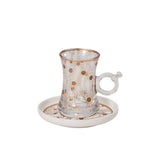 CASA BLU 18-piece luxury tea and coffee set in a black foam-lined gift box, featuring 6 smoked glass tea cups with handles, 6 white porcelain Cawa cups, and matching gold-patterned saucers.