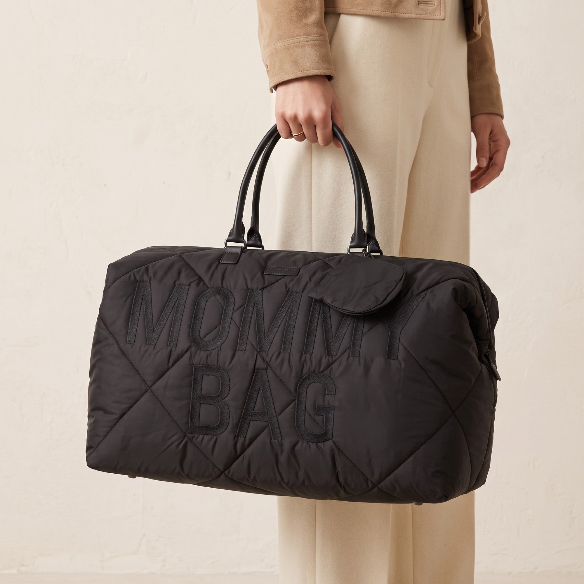 Black quilted duffle bag with 'MOMMY BAG' embroidered on the front, two black top handles, and a small front flap pocket.