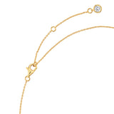 Gold-toned necklace with a lobster clasp, an extender chain, and a small round clear stone in a bezel setting at the end.