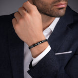 Black leather bracelet with a black-finished metal clasp featuring a double C logo.