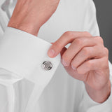 Silver-toned circular cufflink with a polished outer rim, a matte inner circle, and a raised C-shaped design in the center.