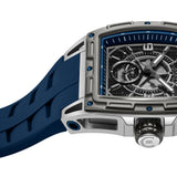 Rectangular silver-toned watch with a dark grey carbon fiber dial, multiple subdials, and blue accents. It has a blue silicon