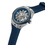 Silver-toned angular watch with a dark blue bezel, blue skeleton dial, and blue ribbed silicone strap.