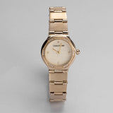 Gold-toned octagonal watch with crystal-studded bezel, textured light gold-toned dial, crystal hour markers, and link bracele