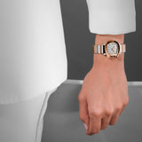 Rose-gold-toned horseshoe watch with a white wavy dial and two-toned metal strap with rose-gold-toned and white links.