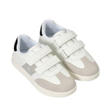 Pair of white low-cut sneakers with light grey suede toe and side panels, three white velcro straps, black heel collar, and a