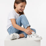 White low-cut sneakers with black outlines, white laces, and a white velcro strap. Black 'CK' logo on the outer side.