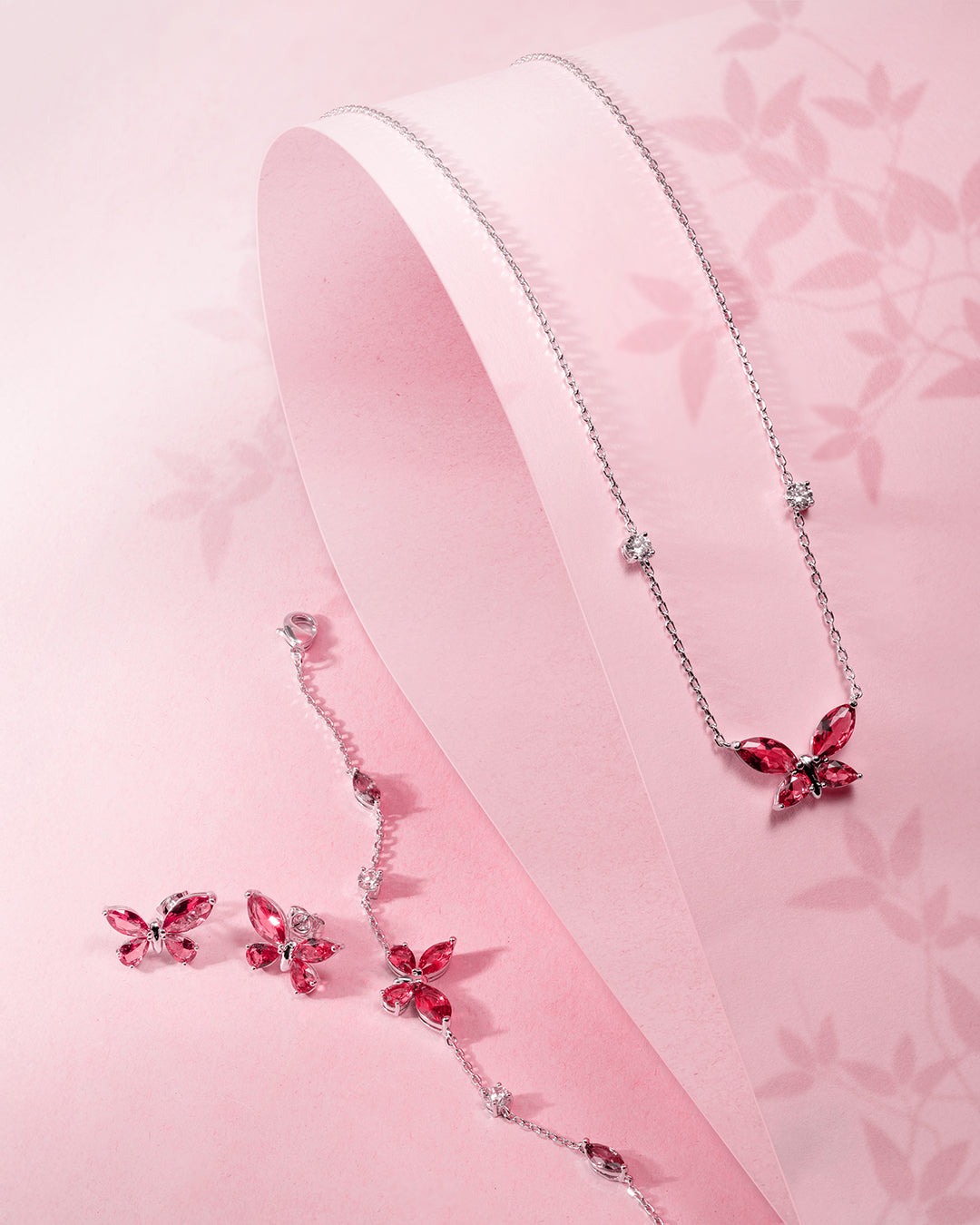 Silver-toned jewelry set: necklace with ruby-red butterfly pendant & clear stones; matching bracelet with butterfly charm & s