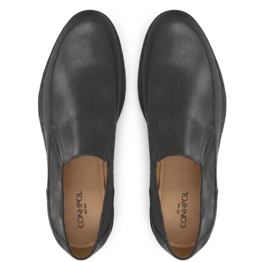 Black slip-on shoes featuring a fine grid texture on the upper, smooth leather sides, and light brown footbeds.