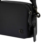 Detailed view of the wide metallic silver leather crossbody strap for the Coach bag, showcasing the polished silver prong buckle, adjustment holes, and heavy-duty dogleash swivel hook.