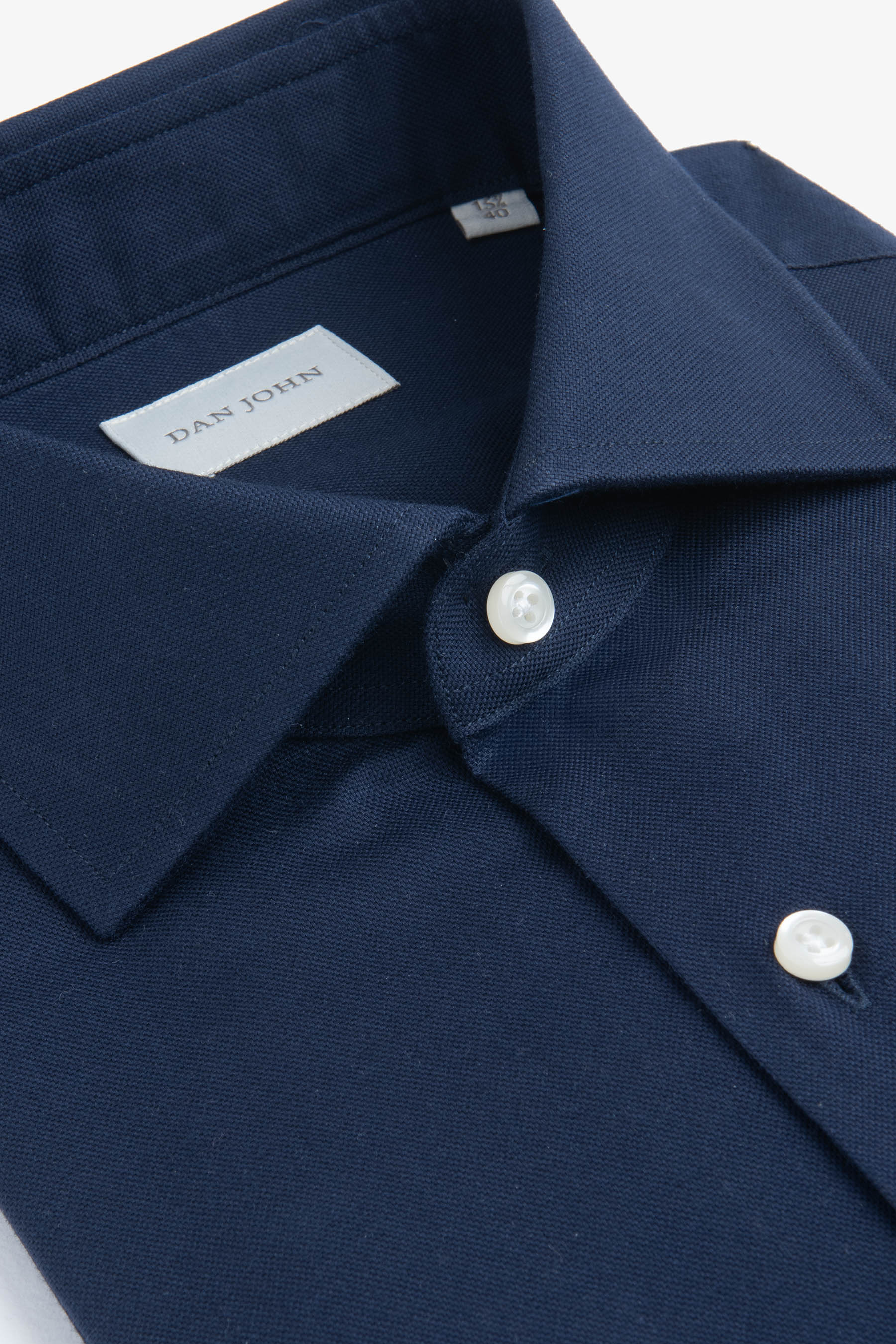 Dark blue collared shirt with a spread collar and two white buttons on the placket. Features a visible fabric texture.