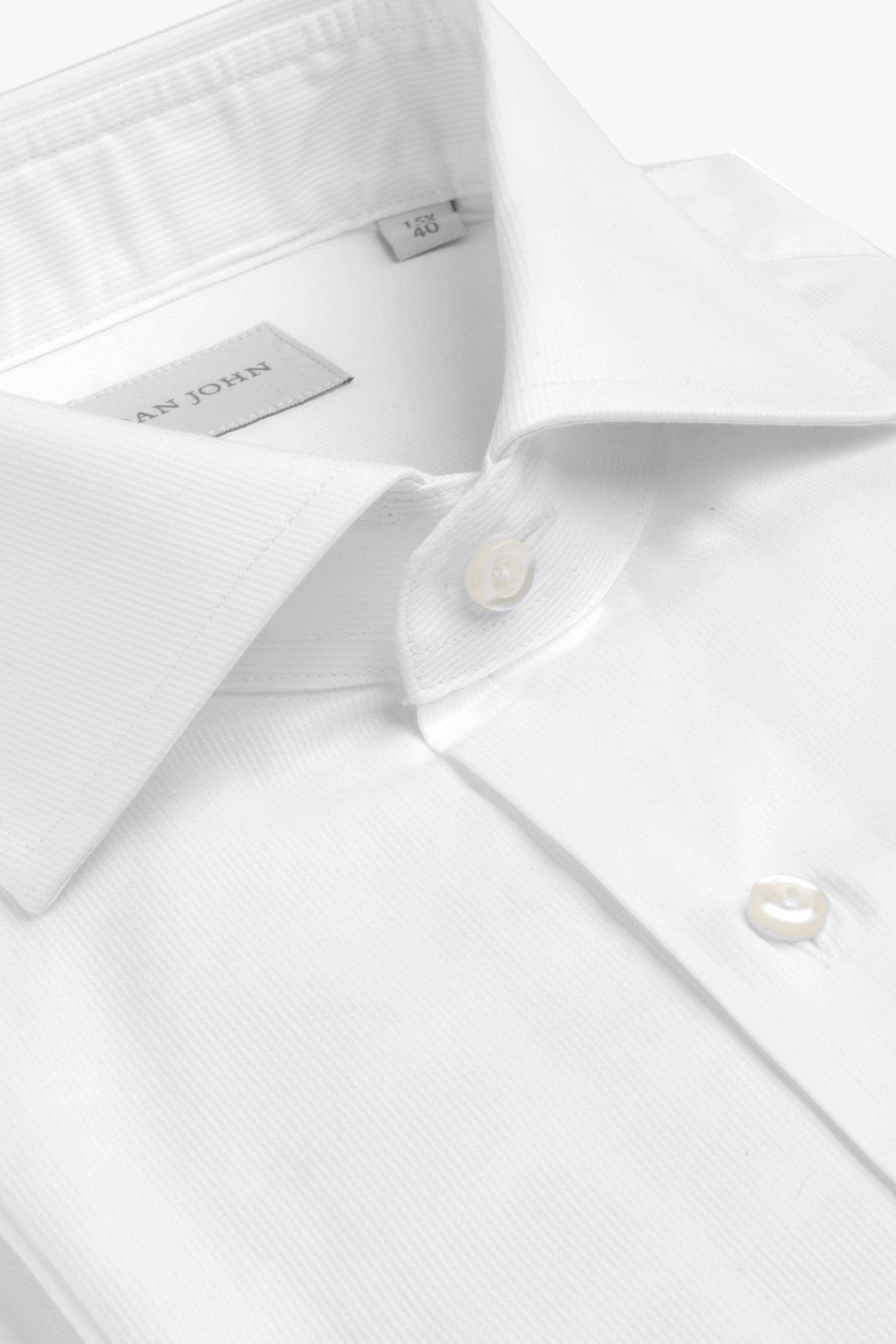 White shirt with a classic collar, fine ribbed texture, and two light-colored buttons on the front placket.