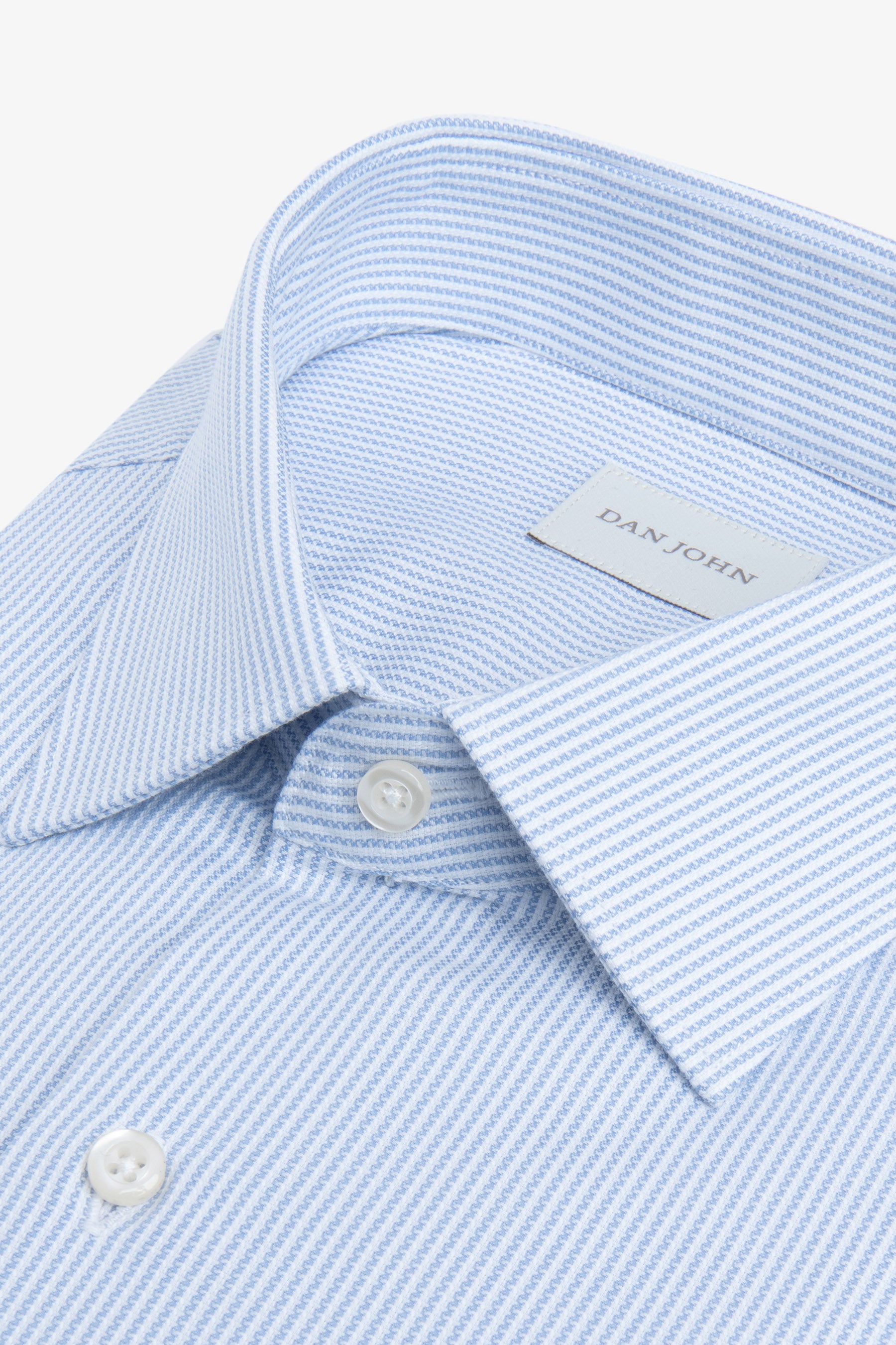Light blue shirt with a fine textured stripe pattern, classic collar, and white buttons.