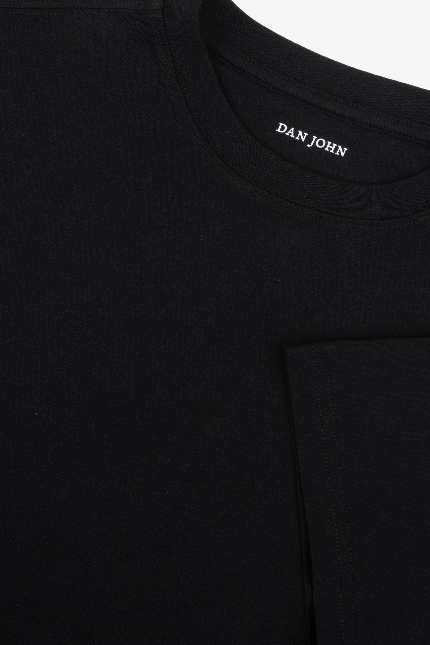 Black crew neck short sleeve t-shirt with a ribbed collar and "DAN JOHN" printed in white on the inner back neck.