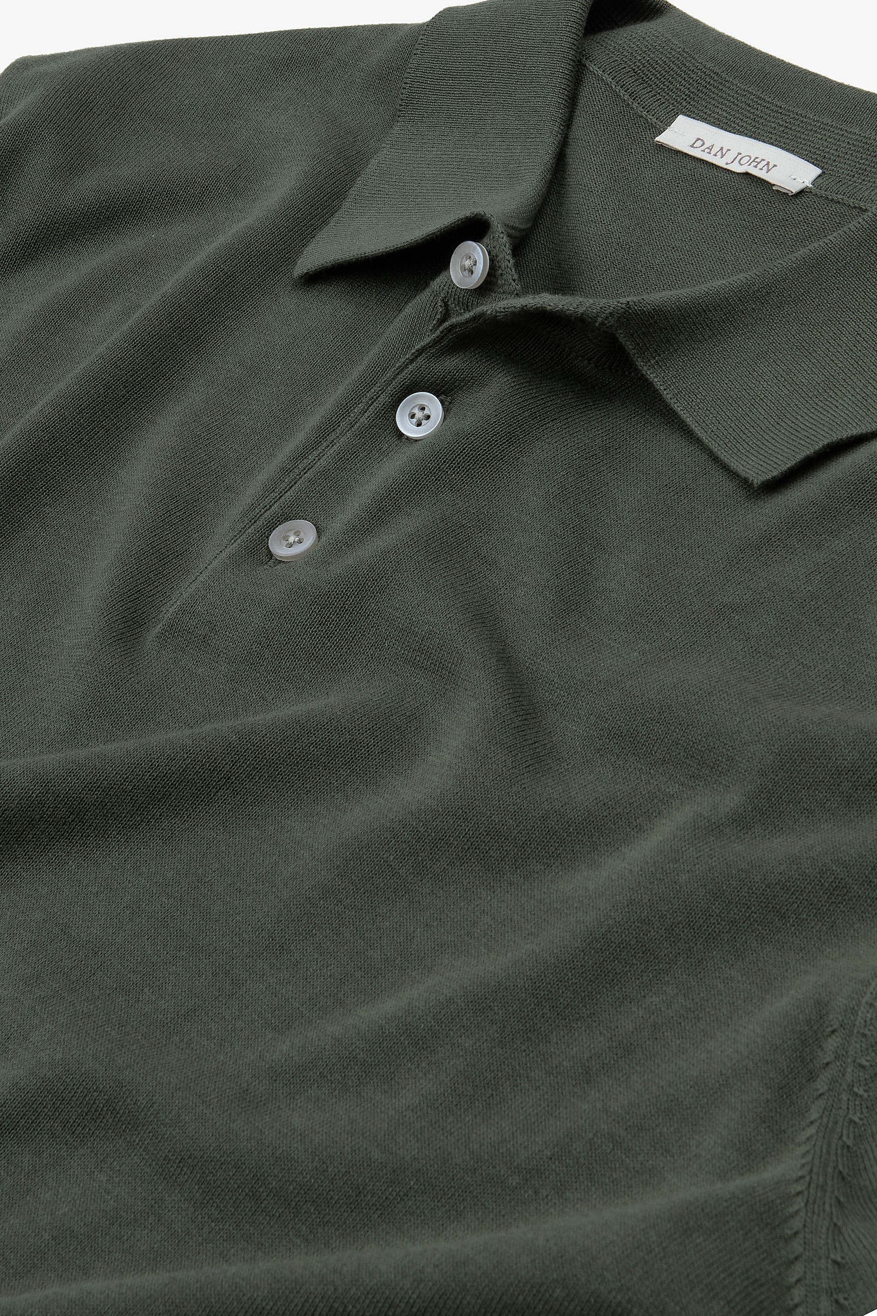 Dark green knit short-sleeve polo shirt with a classic collar, two light pearlescent buttons, and a ribbed sleeve cuff.