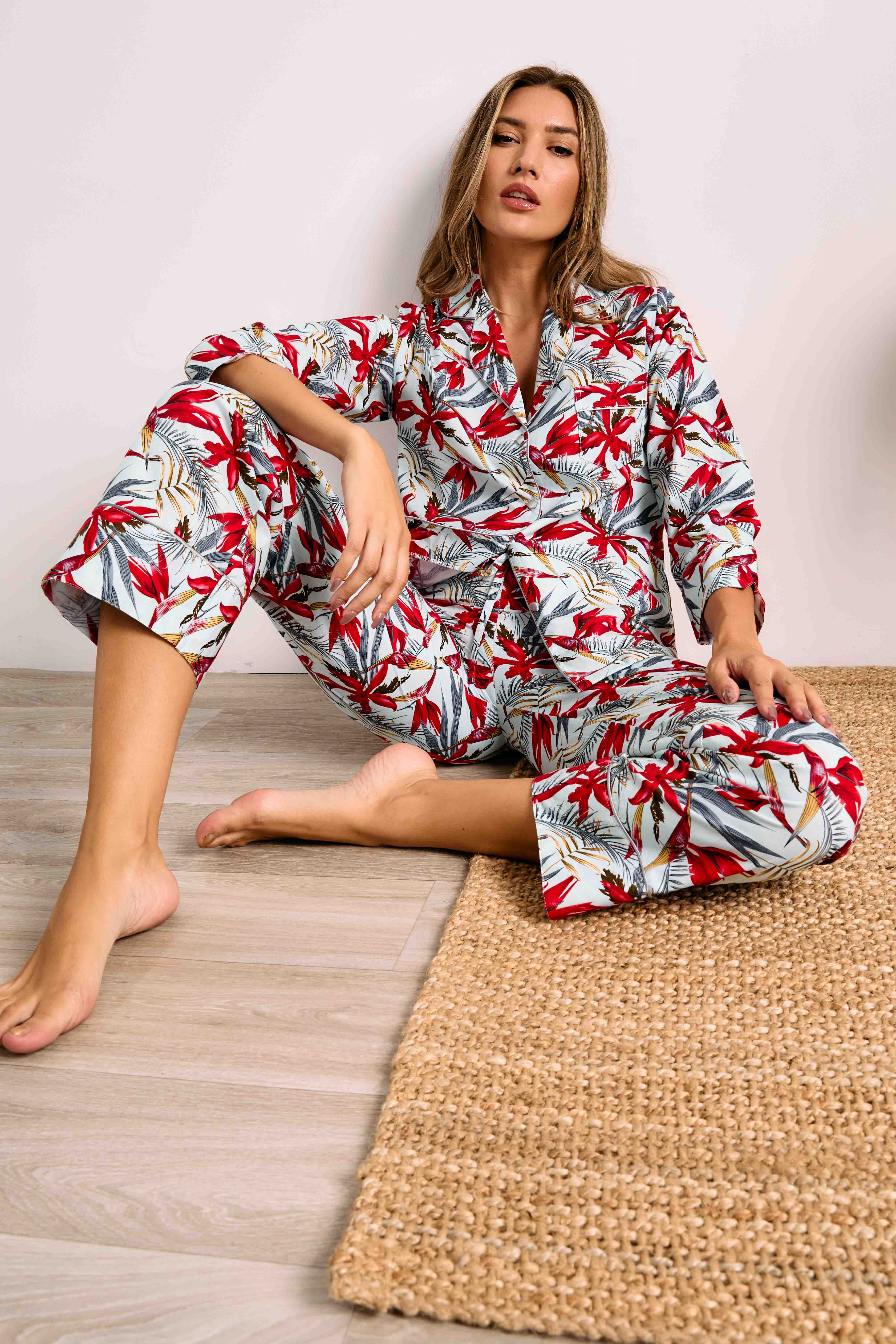 Light blue pajama set with red Birds of Paradise print. Button-up top with collar, pocket, white piping, and cropped pants.