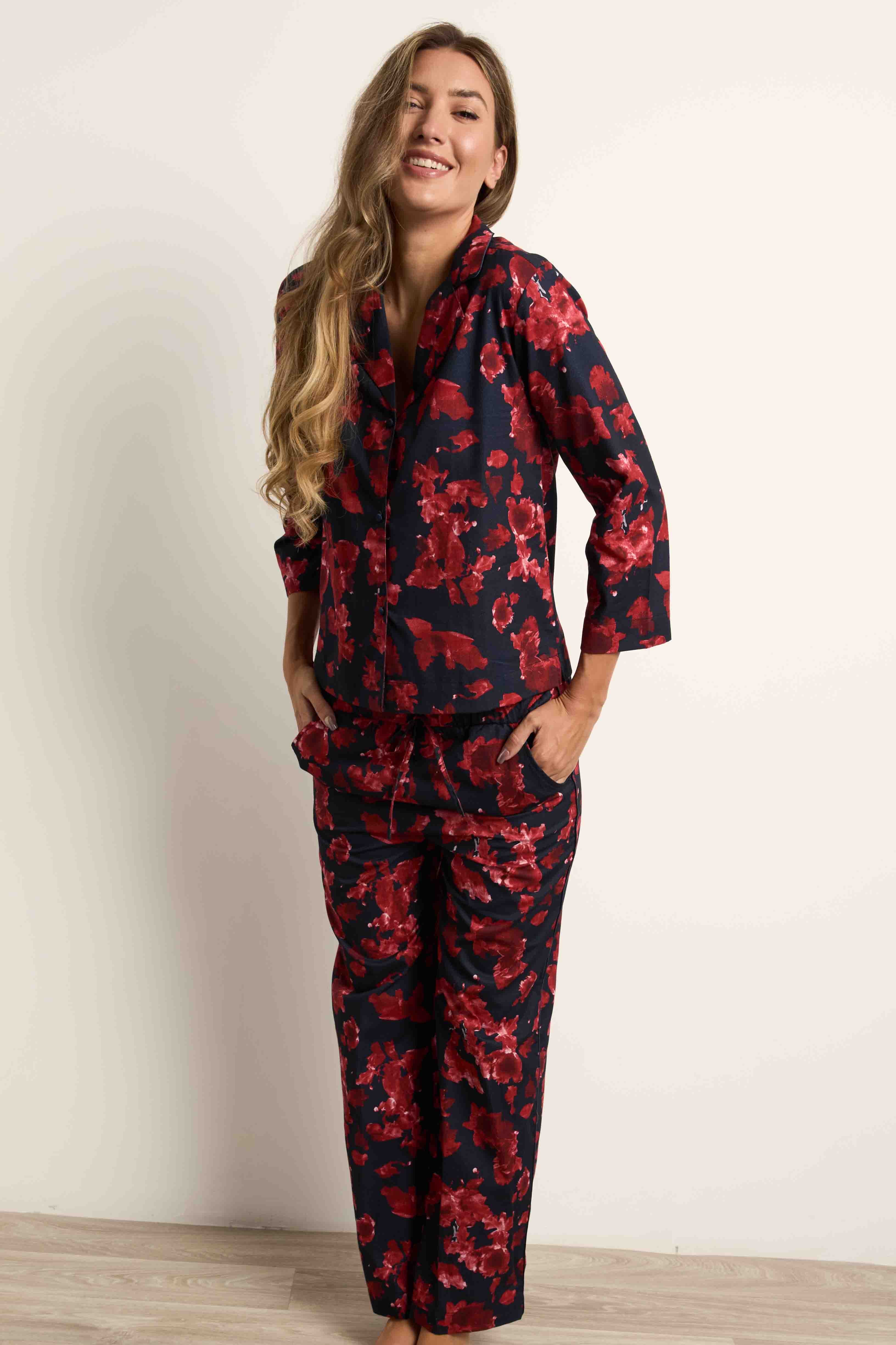 Navy pajama set with crimson red watercolor floral print. Collared button-up top, 3/4 sleeves, drawstring pants with pockets.