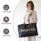 Black fabric tote bag with brown leather-like handles, gold-toned hardware, and 'FAMILY BAG' in large gold-toned letters on t