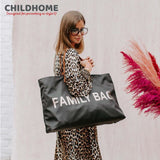 Large black fabric tote bag with "FAMILY BAG" in gold-toned letters on the front and a brown shoulder strap.