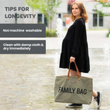 Kaki canvas tote bag with brown faux leather handles, gold-toned rivets, and 'FAMILY BAG' printed on the front.