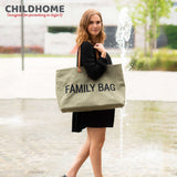 Kaki canvas tote bag with 'FAMILY BAG' in black text. Features two brown leather-look shoulder straps with gold-toned rivets.