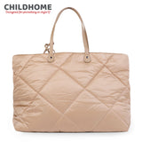 Beige quilted puffer tote bag with two light brown top handles attached by silver-toned rivets. Features a diamond stitch pat