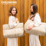 Beige quilted tote bag with diagonal stitching, featuring "FAMILY BAG" in white text on the front. Has two beige top handles