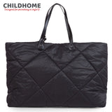 Black puffer tote bag with diamond quilting. Features two black handles attached by oval patches and silver-toned fasteners.