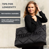 Black puffed quilted tote bag with 'FAMILY BAG' text on the front and black shoulder straps.