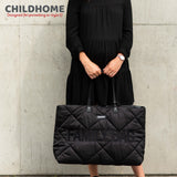 Black quilted puffy changing bag with "FAMILY BAG" text, two black top handles, and silver-toned hardware.