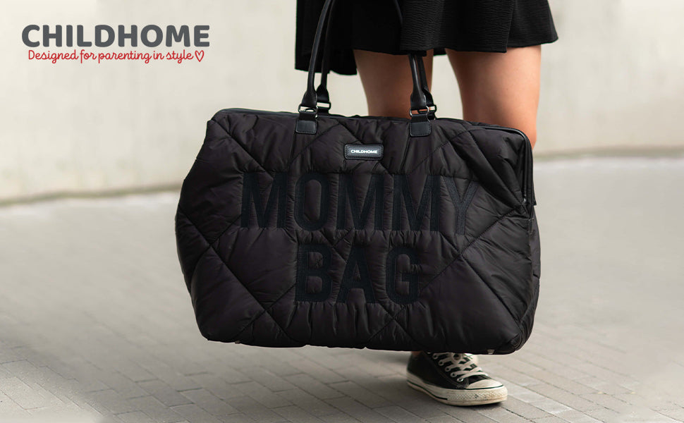 Large black quilted duffel bag with diamond pattern, 'MOMMY BAG' text, two black top handles, and a 'CHILDHOME' label.