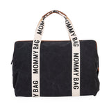 Black canvas rectangular bag with cream woven top handles featuring 'MOMMY BAG' text and brown faux leather trim.