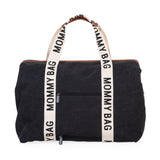 Black canvas tote bag with brown trim, two cream "MOMMY BAG" straps, and two front zippers with "CHILDHOME" pulls.