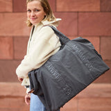 Dark grey fabric tote bag with wide straps and 'MOMMY BAG' embroidered vertically on the front and horizontally on the straps