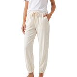 Model wearing the Citizens of Humanity beige drawstring jogger pants paired with a casual white t-shirt, showcasing the relaxed, tapered drape and side pocket placement.