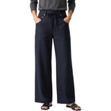 Cropped model shot of a person wearing Citizens of Humanity high-rise wide-leg drawstring trousers in navy, styled with a grey knit top and black leather slides.