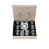 Top-down view of an 18-piece Casa Blu luxury drinkware set in a presentation box, featuring 6 tea glasses, 6 Cawa cups, and 6 saucers with a teal Lily of the Valley floral pattern.
