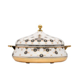Casa Blu luxury white insulated food warmer with gold-plated base and handles, decorated with black and gold geometric sunburst patterns on the body and lid.