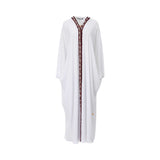 Front view of a CASA JOHARA FASHION white butterfly kaftan featuring a V-neckline and a long vertical strip of burgundy beads and white pearls.