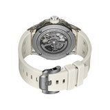 Rear perspective view highlighting the clear crystal exhibition caseback revealing the automatic rotor mechanism, paired with the engraved gunmetal pin buckle on the beige silicone band.