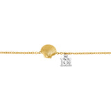 A detailed linear macro shot focusing on the center of the Escada Margarete bracelet, highlighting the gold-plated ridges of the scallop shell charm next to the silver-colored stainless steel cutout double-E logo.