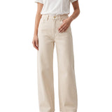 Cropped model shot of a person wearing Citizens of Humanity high-rise wide-leg jeans in ecru cream, styled simply with a tucked-in white t-shirt.