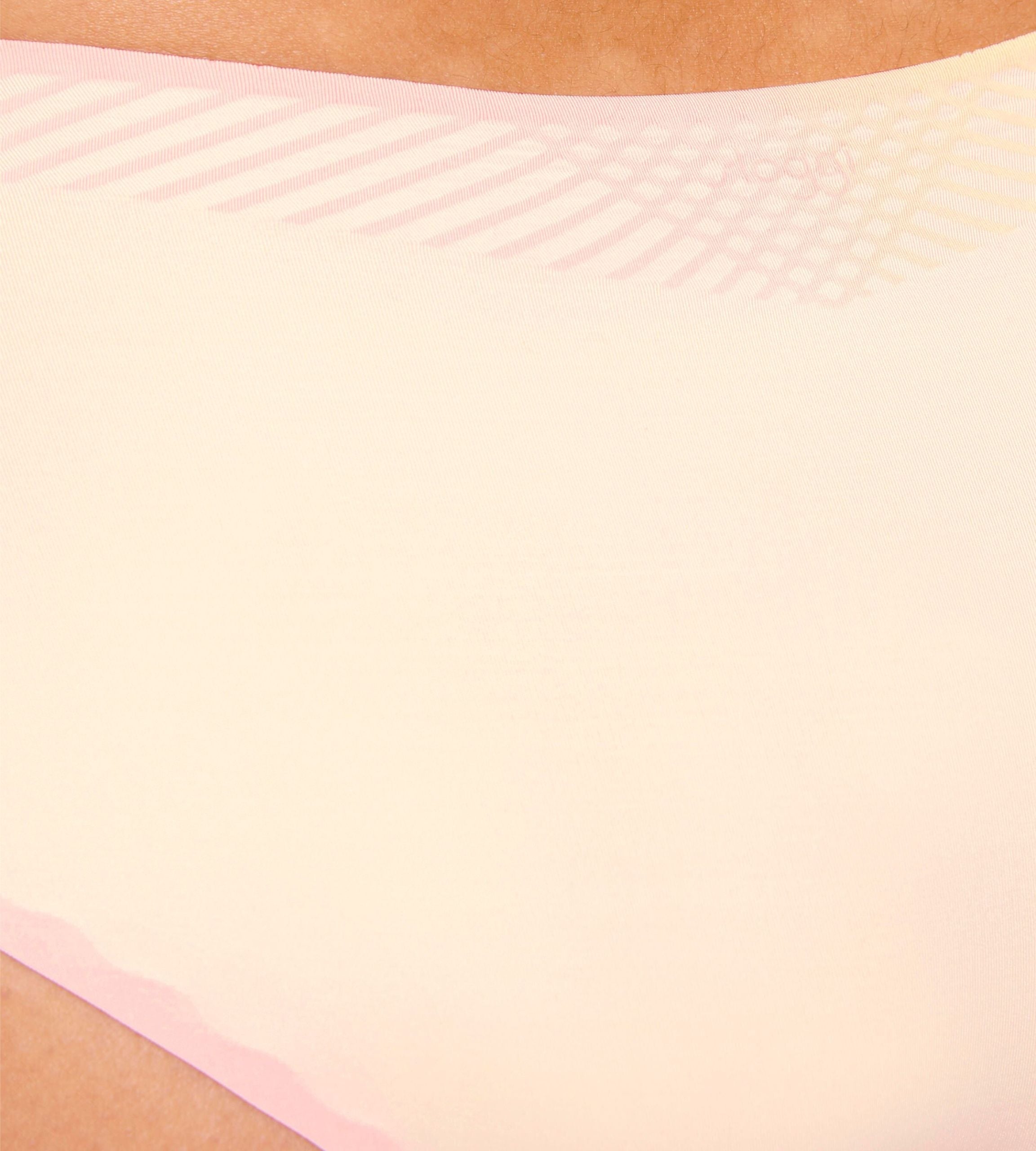 Close-up view of model wearing the Sloggi Body Adapt Twist hipster panty in peach cream, highlighting the mesh waistband and seamless laser-cut edges.