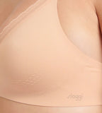 Close-up view of model wearing the Sloggi Body Adapt Twist soft bra in powder orange, highlighting the mesh neckline and wire-free construction. Find Now Online