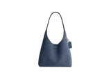 Front view of the Coach Brooklyn Shoulder Bag blue leather featuring a slouchy silhouette and gold-tone magnetic snap detail on the front pocket.