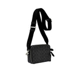 Side profile view of the black Coach Tabby messenger bag showing its expandable multi-gusset structure, neat finished edges, and the black dogleash clasp attaching the wide strap.