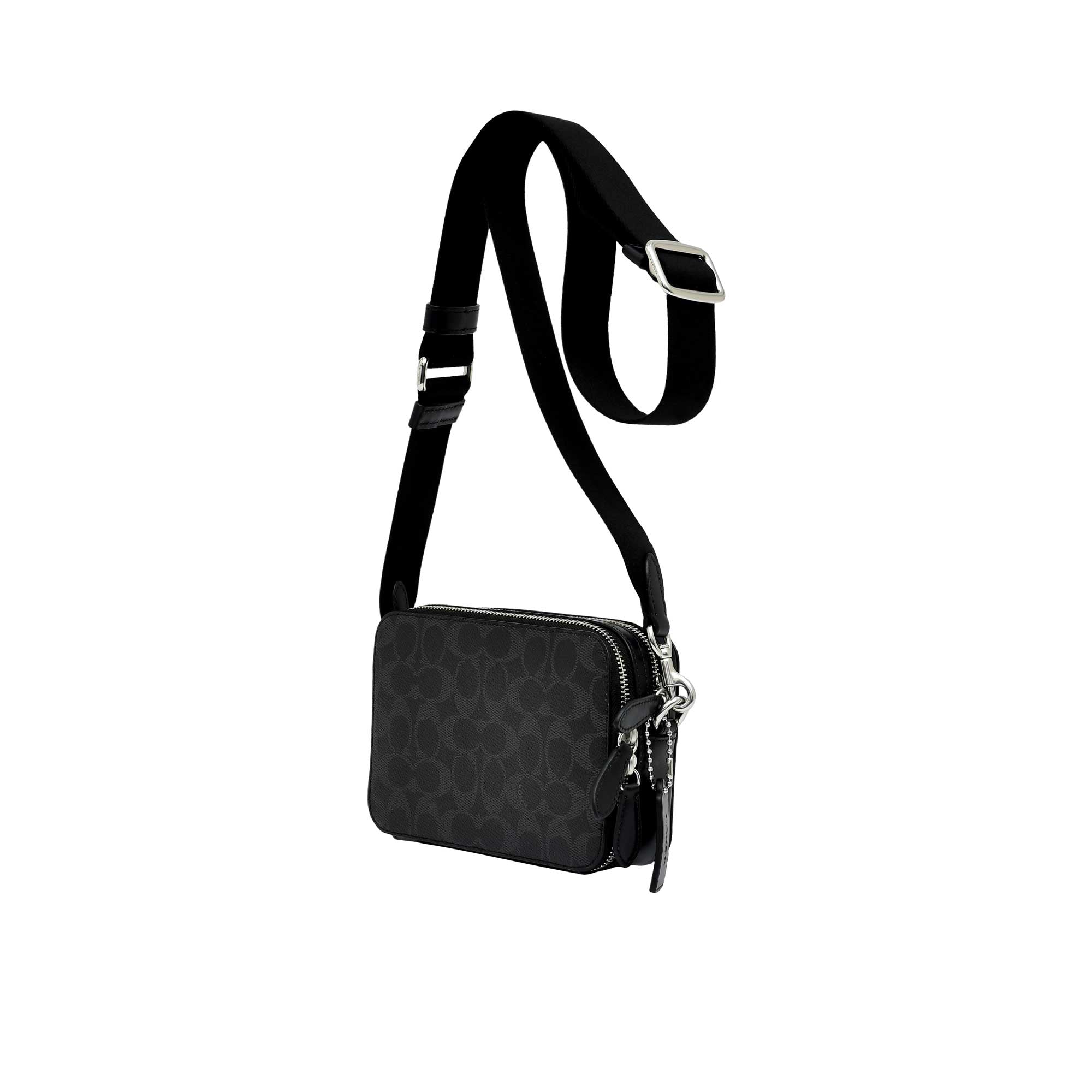 Side profile view of the black Coach Tabby messenger bag showing its expandable multi-gusset structure, neat finished edges, and the black dogleash clasp attaching the wide strap.